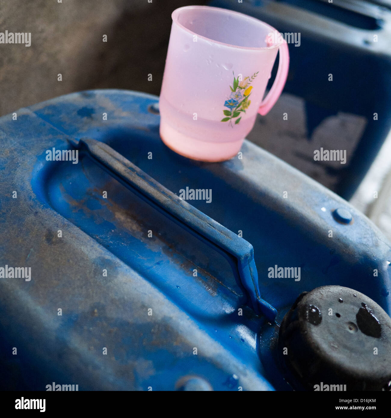 Rosa Plastik Krug auf einem großen blauen Kunststoff Flüssigkeitsbehälter zu messen Stockfoto