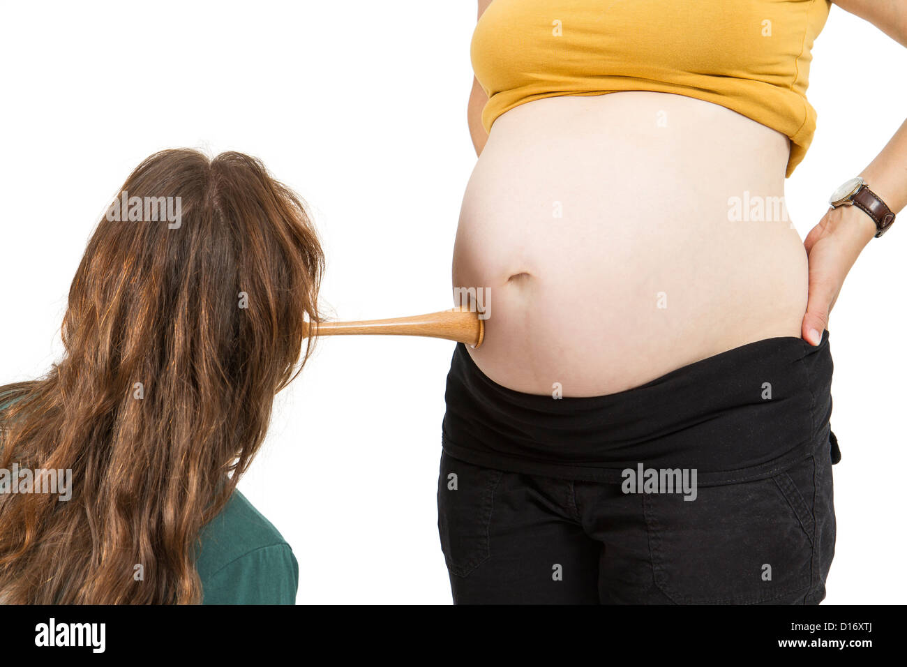 junge Hebamme am menschlichen Bauch hören. Schwangere Frau stehen, während vorne, Hebamme sitzt Stockfoto