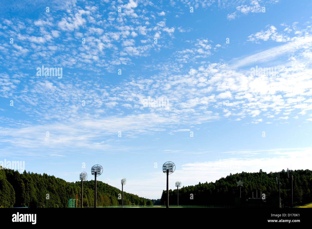 Baseball-Feld-Beleuchtungssystem und blauer Himmel mit Wolken Stockfoto