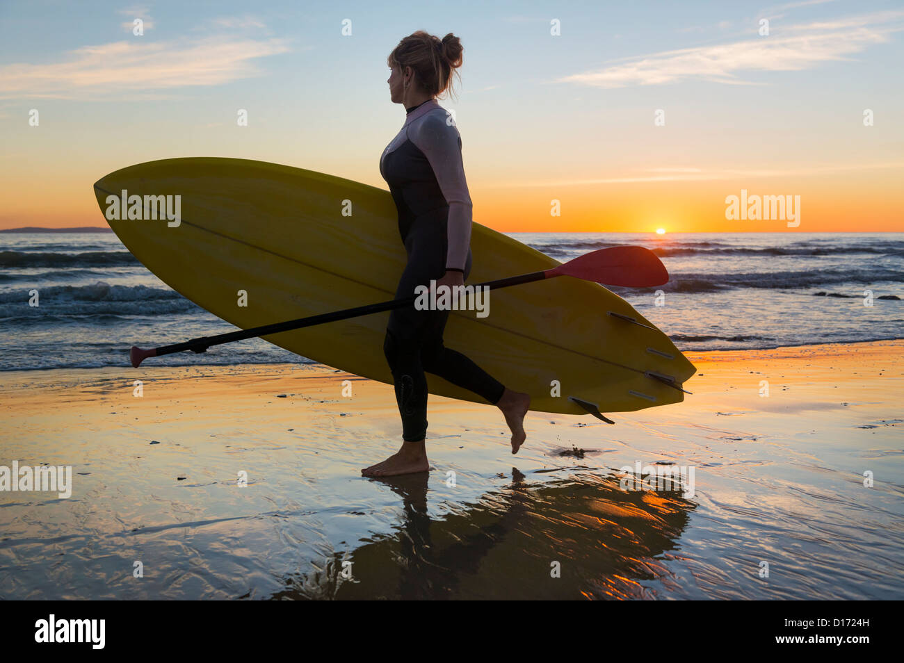 Frau bei Sonnenuntergang mit ihrem Stand-up Paddle Surfboard. Tarifa, Costa De La Luz, Cádiz, Andalusien, Spanien. Stockfoto