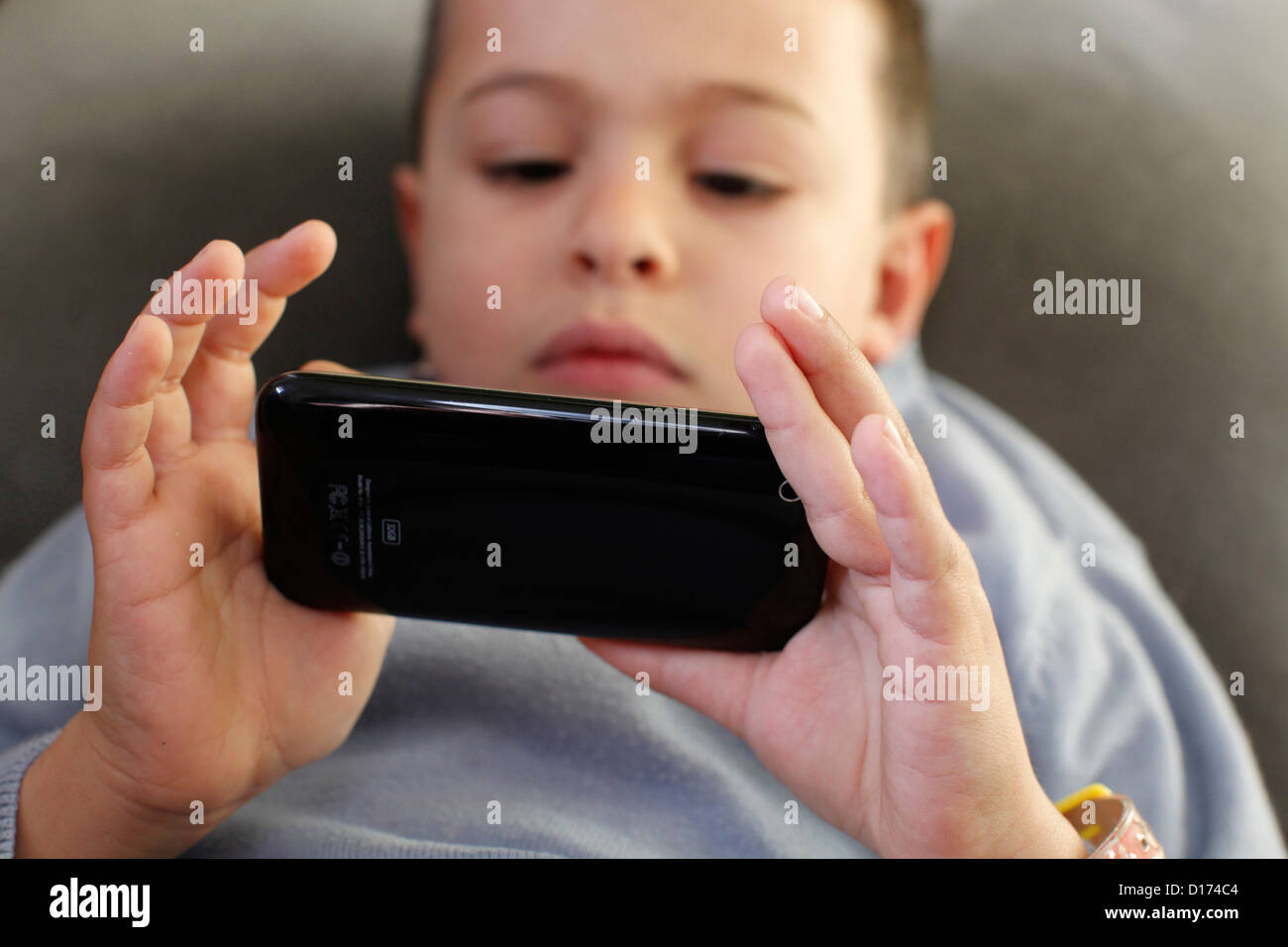 6-jähriger Junge mit einem Iphone spielen Stockfoto