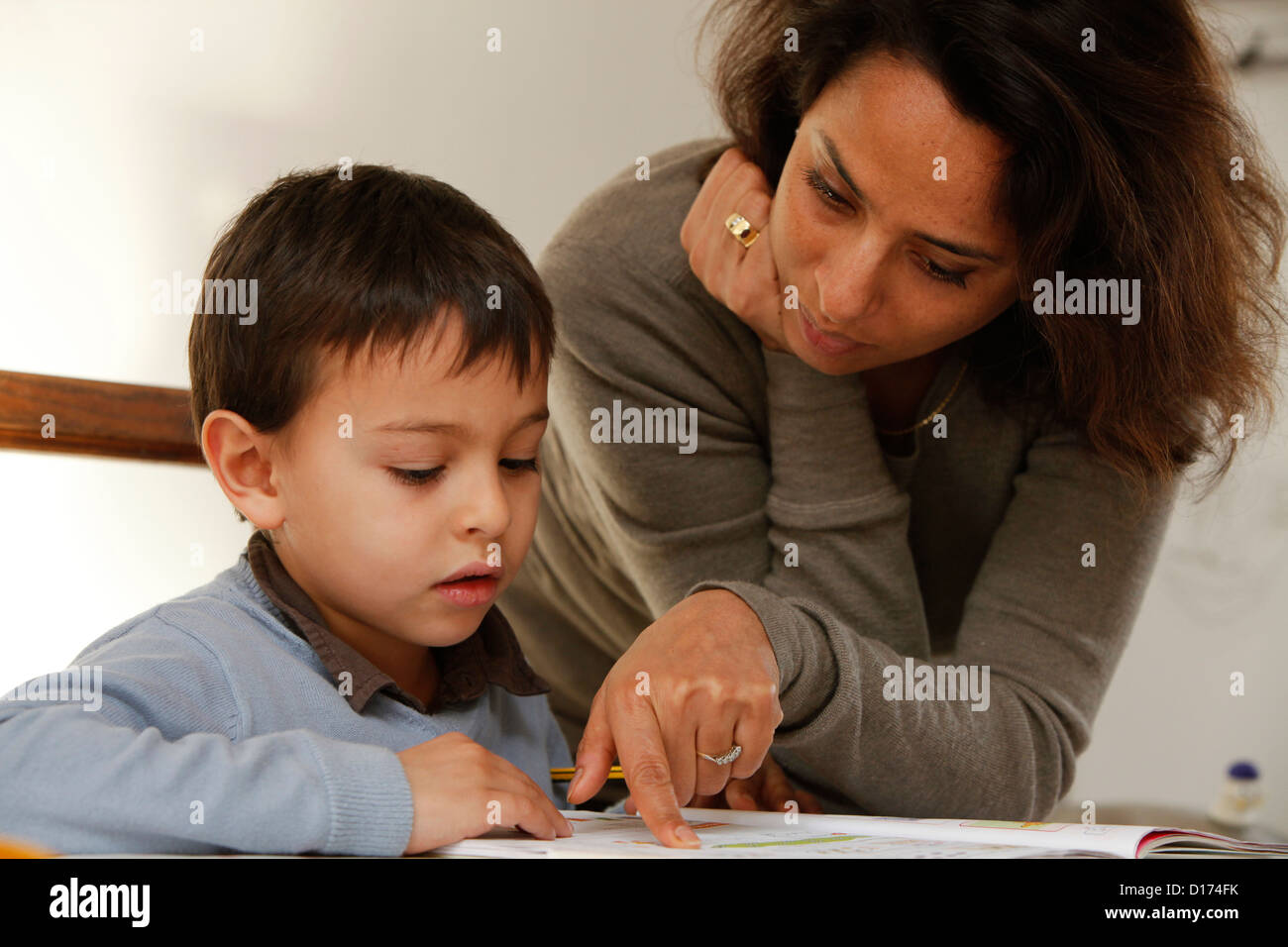 Mutter ein 6 Jahre alten Jungen mit seinen Hausaufgaben zu helfen Stockfoto