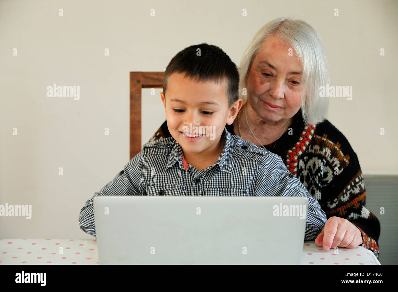 6-jähriger Junge Blick auf einem Laptop mit seiner Großmutter Stockfoto