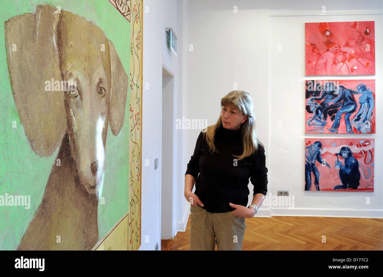 Ein Museums-Mitarbeiter sieht das Gemälde "für den Hund, wenn es gut, 1997' (L) von Barbara Quandt im Museum"Syker Vorwerk"in Syke, Deutschland, 7. Dezember 2012 angezogen hat. Die Bilder sind Teil der Sonderausstellung "Künstlerische Ansichten an Tieren", die 9. Dezember 2012 bis 17. März 2013 entnehmen kann. Foto: Ingo Wagner Stockfoto