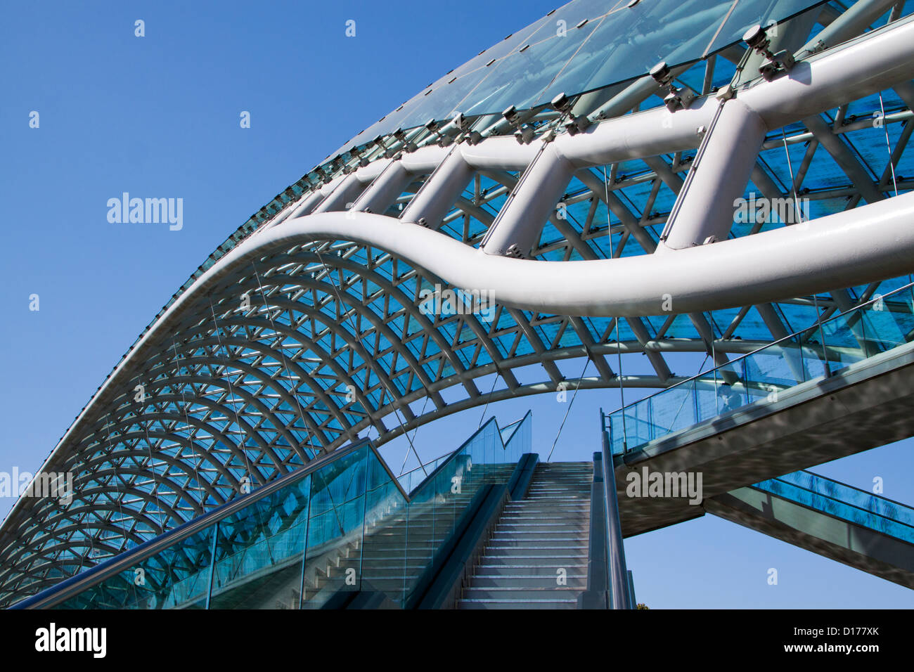 Die Wahrzeichen Brücke des Friedens in zentralen Tiflis, Georgien, an einem sonnigen Tag gegen blauen Himmel Stockfoto