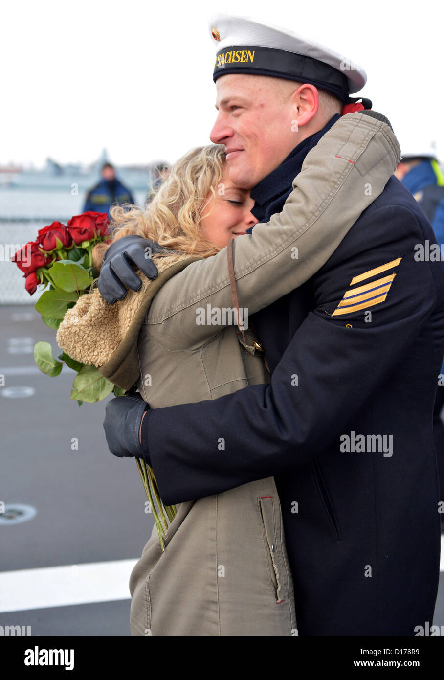 Petty Officer Third Class Martin Barthelmes (R) umarmt seine Freundin Christina, die seinen Heiratsantrag nach der Fregatte "Sachsen" (Sachsen) zurückgegeben, den Marinehafen in Wilhelmshaven, Deutschland, 7. Dezember 2012 angenommen. Das Schiff zurück nach der Teilnahme für fünf Monate in der anti-piracy-Mission Atalanta. Foto: Carmen Jaspersen Stockfoto