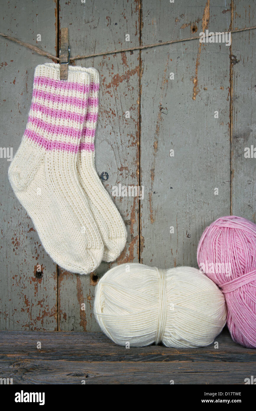 Wollsocken in rustikale Vintage-Einstellung mit rosa und weißen Garn - stricken Konzept Stockfoto