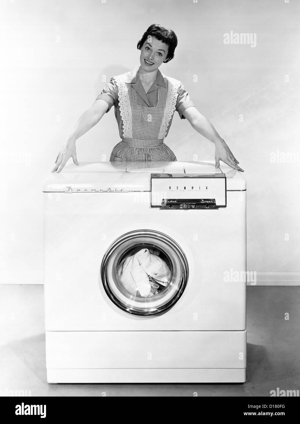 Frau posiert mit Waschmaschine Stockfoto