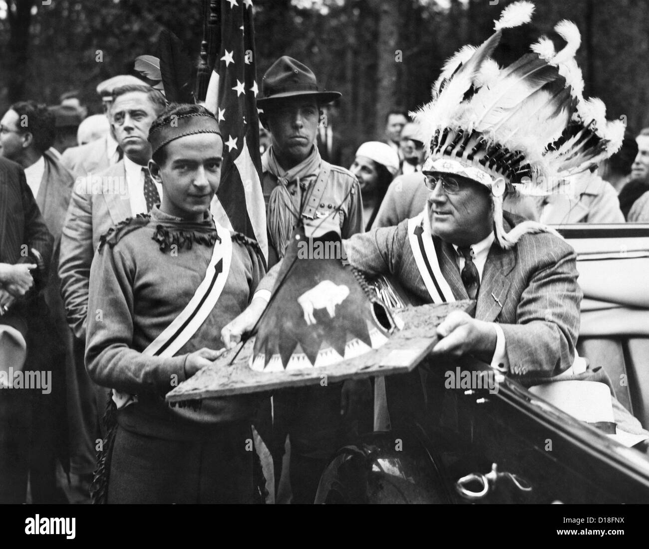 Präsident Franklin d. Roosevelt in einem Krieg Motorhaube. FDR trägt indischer Kopfschmuck, als bekommt er eine Miniatur indianischen Tipi aus Stockfoto