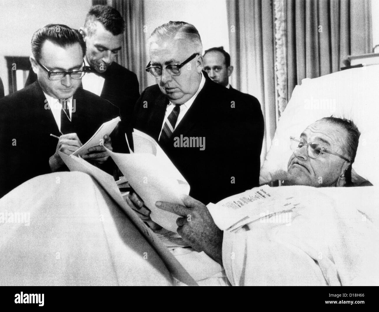 Präsident Lyndon Johnson arbeiten im Bett nach Gallenblasen-Operation. Präsident Johnson blickt auf Dokumente in seinem Krankenhausbett Stockfoto