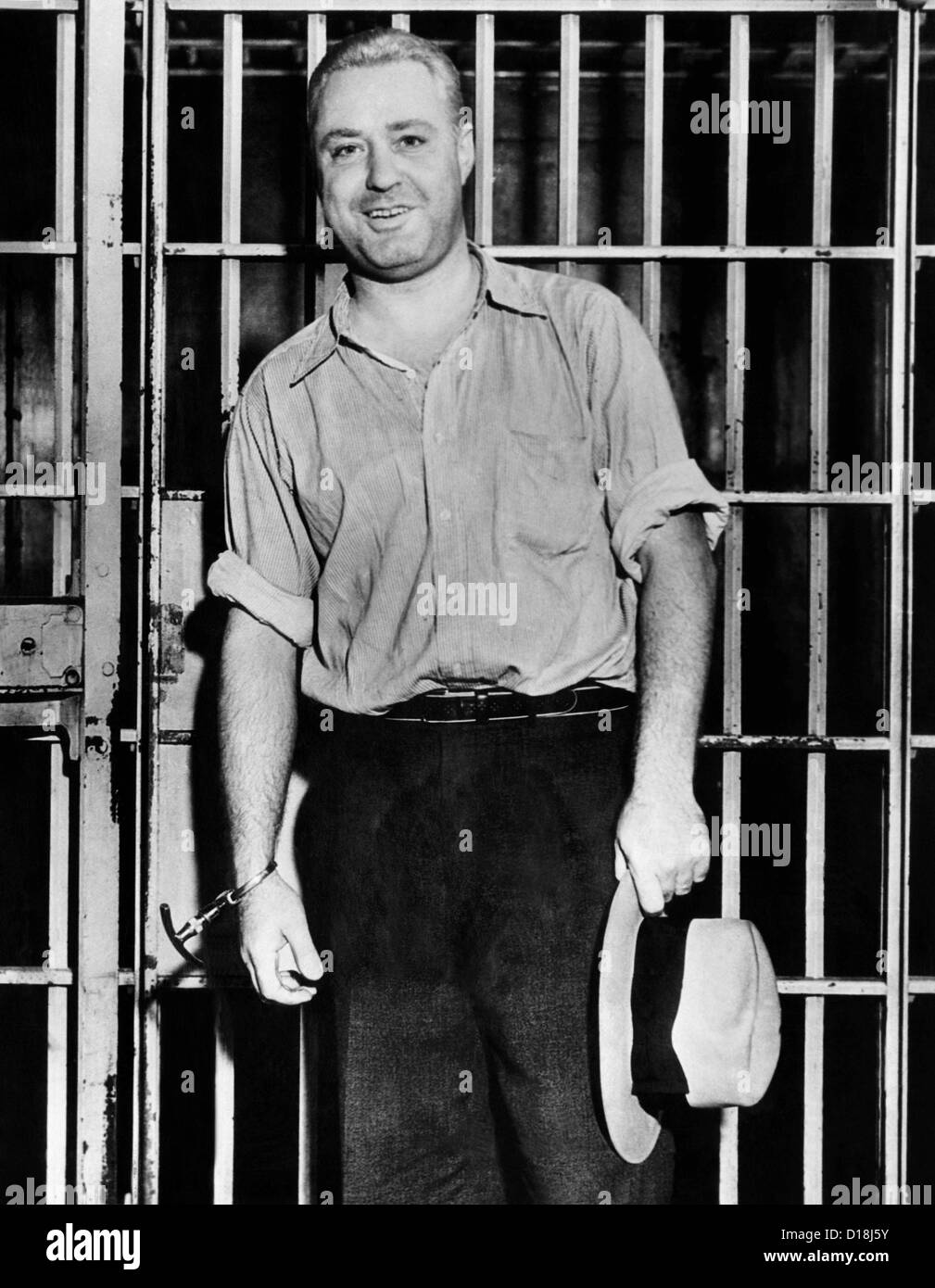 "Machine Gun" Kelly, mit Handschellen gefesselt, Gitterstäbe, Lächeln für die Fotografen in seiner Gefängniszelle in Memphis. 26. September 1933. Stockfoto