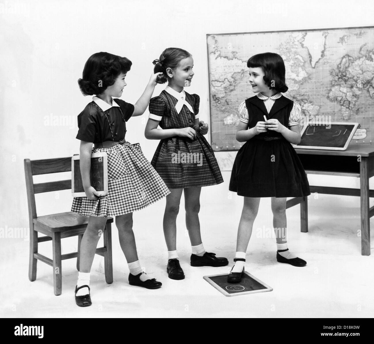 Kleine Mädchenschule gekleidet im Jahr 1953. Sie wiederholen die "Diors New Look", mit ihren gesammelten Röcke und Gürtel Taille getragen Stockfoto