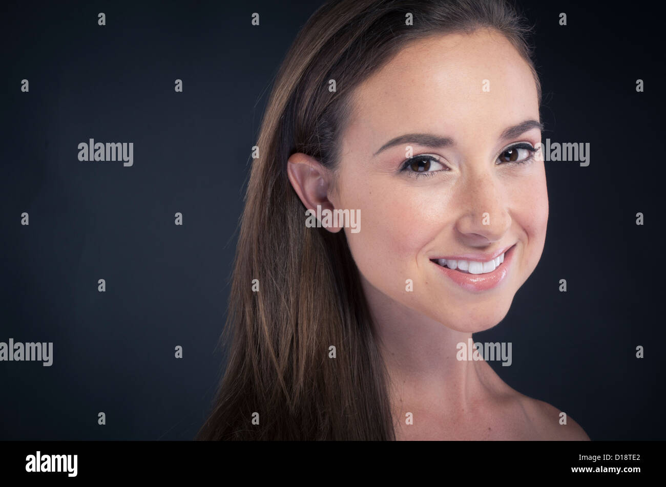 Junge schöne Frau lächelnd auf schwarzem Hintergrund Stockfoto