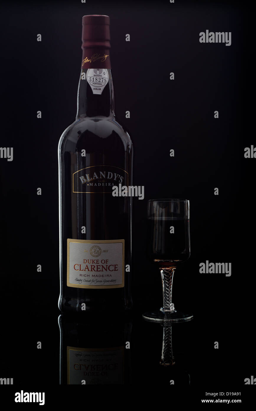 Blandy es Herzog von Clarence reichen Madeira-Wein in Flaschen gezeigt und in einem kleinen Sherry wie Glas auf einem dunklen schwarzen Hintergrund Stockfoto