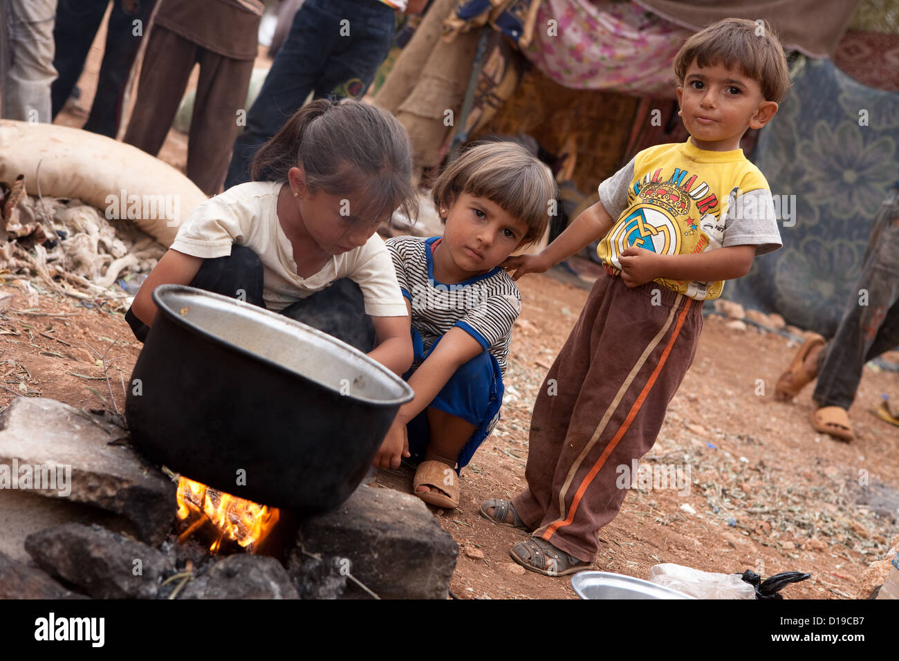 Atmah Flüchtlingslager, Atmah, Syrien, 10.02.12. Kinder kochen über einem Lagerfeuer. Stockfoto