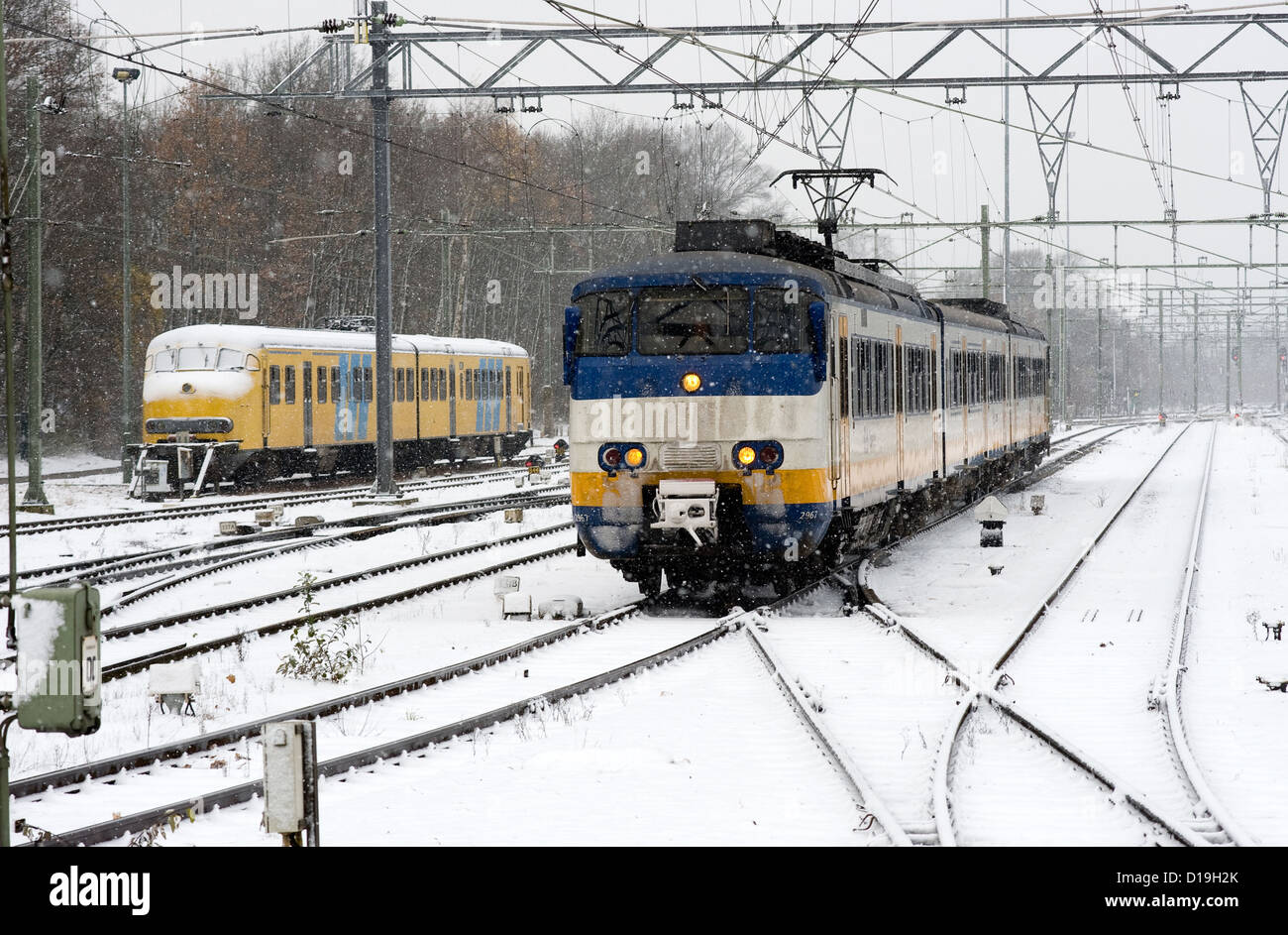 Ein Zug ist auf einem schneebedeckten Bahnhof in der Cwinter ankommen. Stockfoto