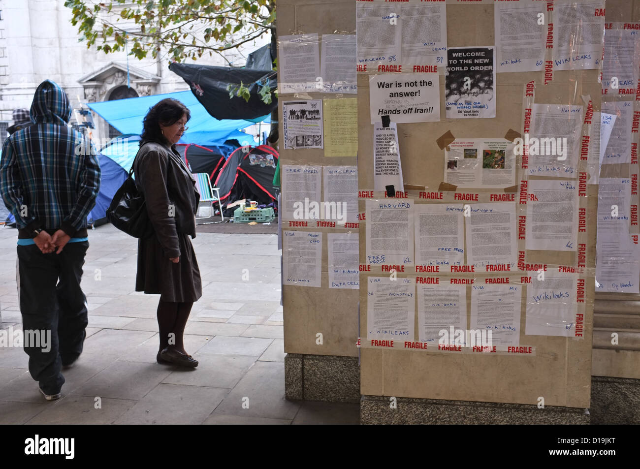 Eine Frau liest Protest-Plakate ausgehängt in der Nähe von London zu besetzen-Anti-Captalist-Protest-Camp außerhalb St. Pauls Cathedral im November Stockfoto