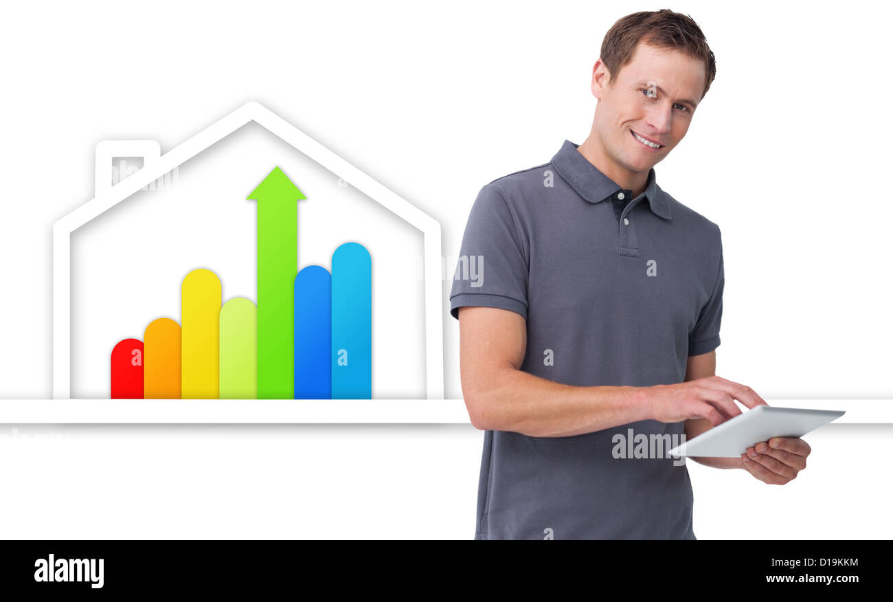 Mann mit Tablette gegen Energie-effiziente Haus-Grafik Stockfoto