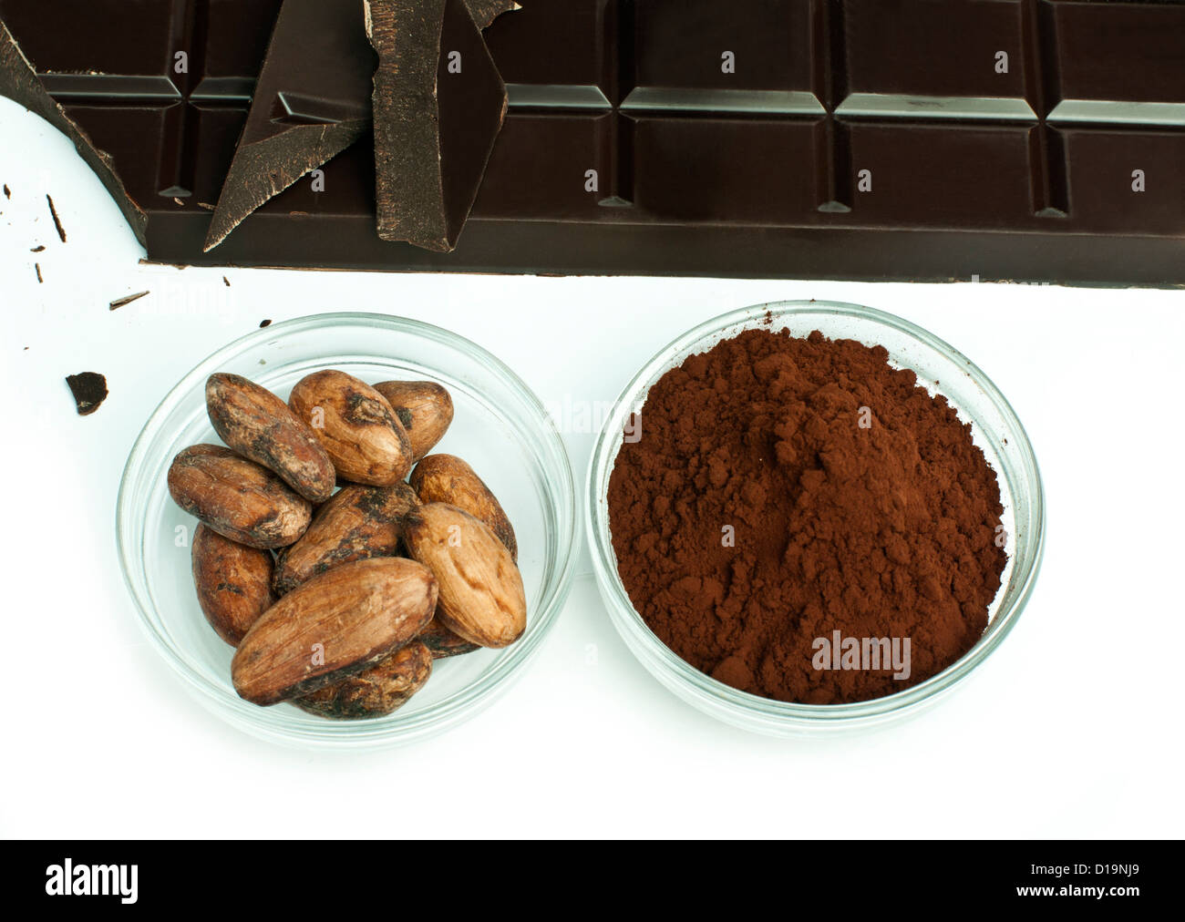 Kakaobohnen, Kakao-Pulver in weißen Schalen und Schokolade Bar isoliert Stockfoto