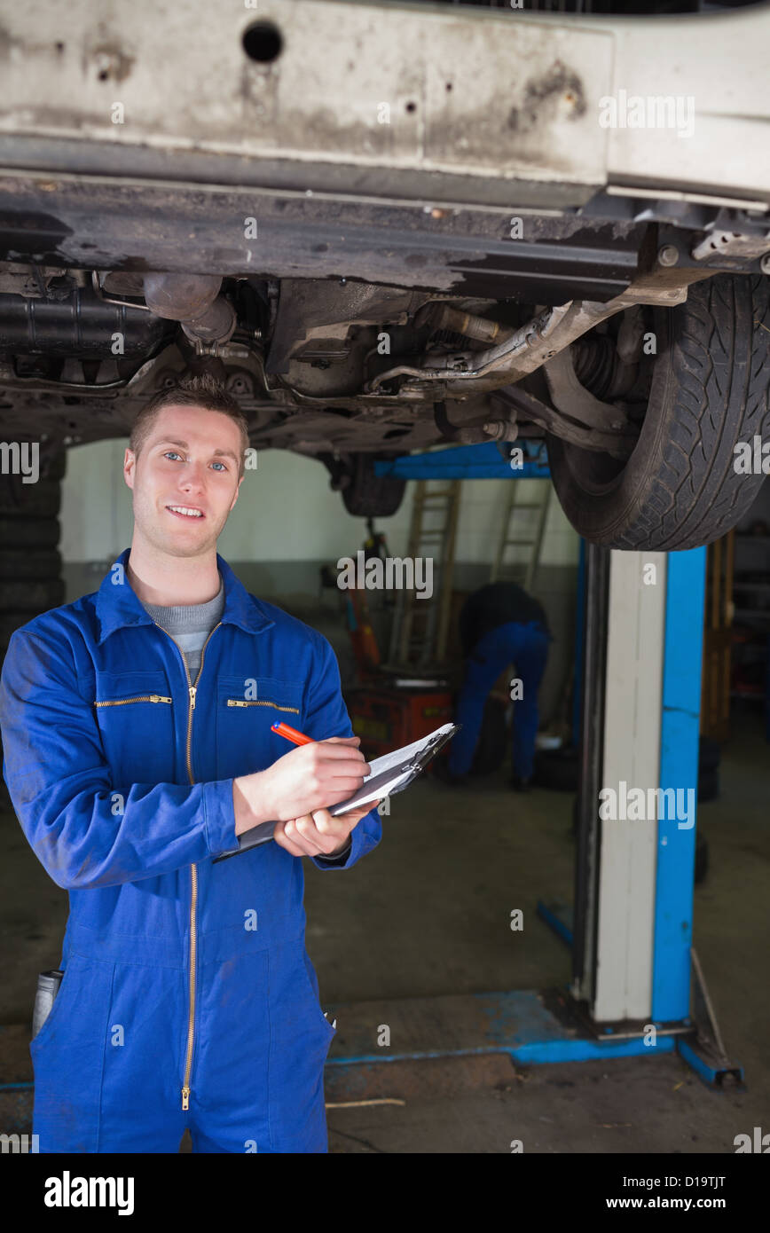 Mechaniker Vorbereitung Checkliste unter Auto Stockfoto