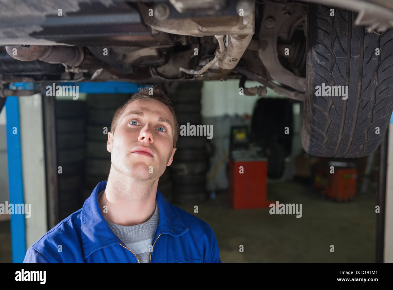 Mechaniker, stehend unter Auto Stockfoto