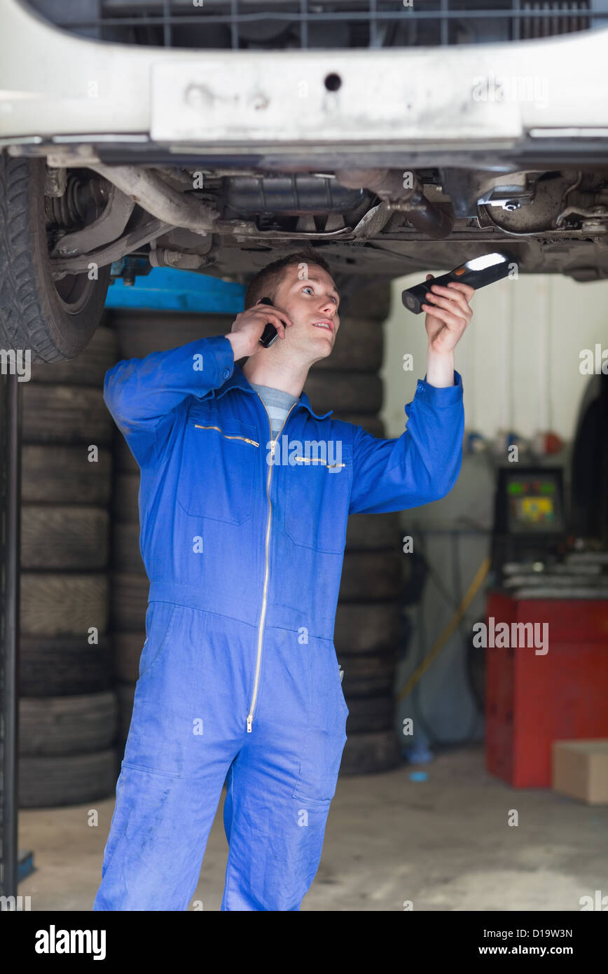 Mechaniker auf Abruf, wie er Auto untersucht Stockfoto