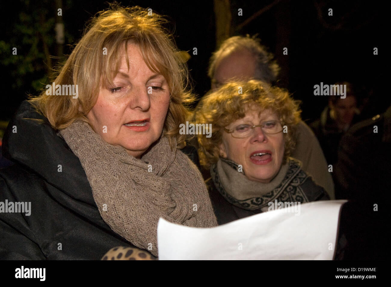 Lokale Bewohner trotzen der Kälte und Gesang an einem Abend im Freien carol Service zur Weihnachtszeit, Farnham, Surrey, Großbritannien. Stockfoto