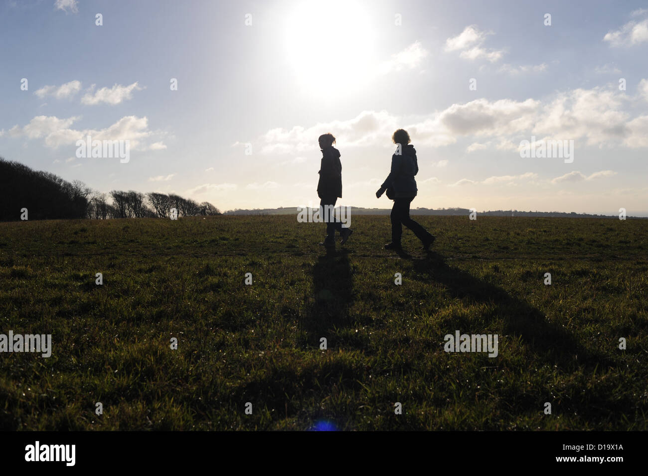 Zwei Frauen, die auf dem Land spazieren, vor blauem Himmel Stockfoto