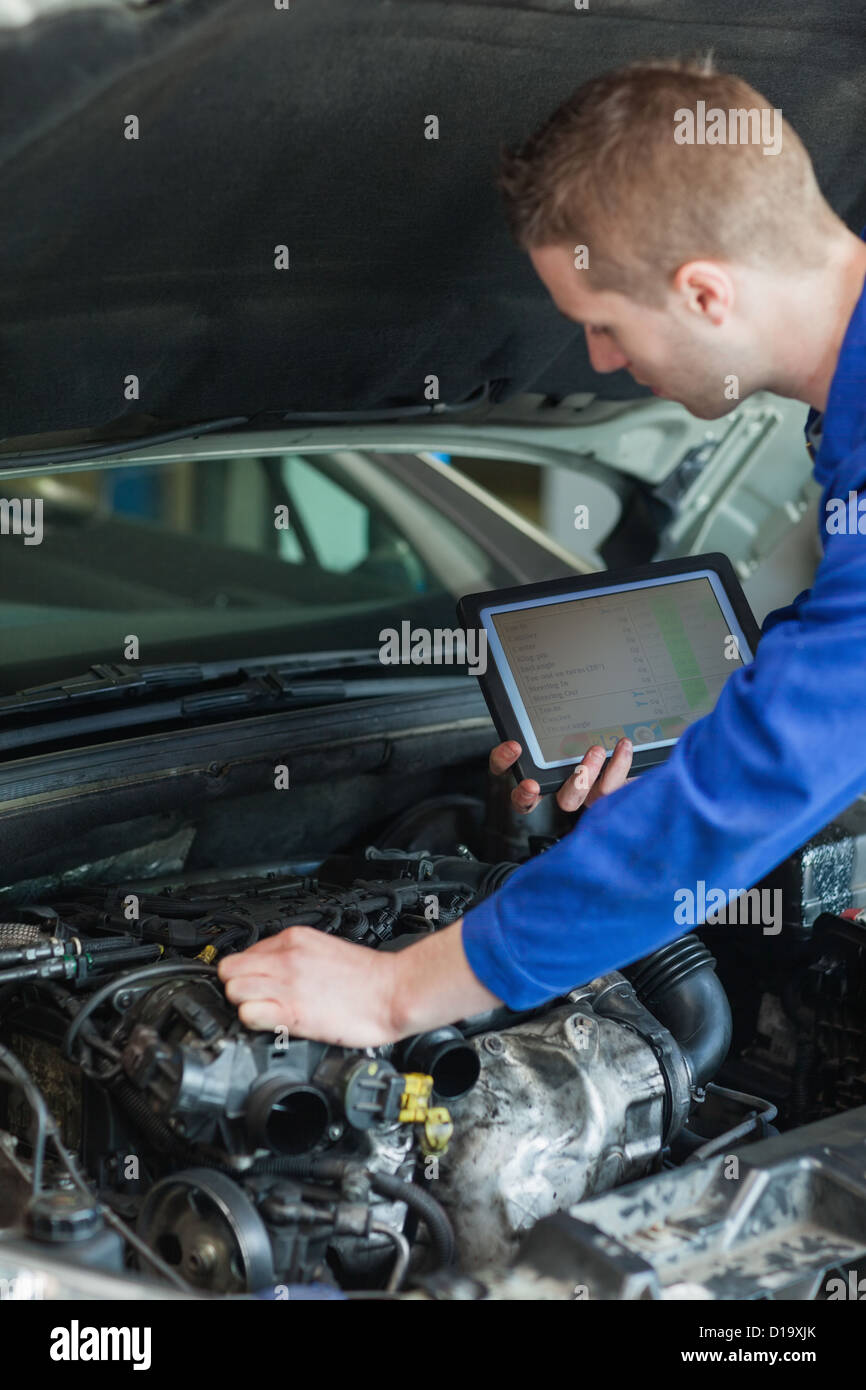 Mechaniker mit TabletPC Reparatur Automotor Stockfoto