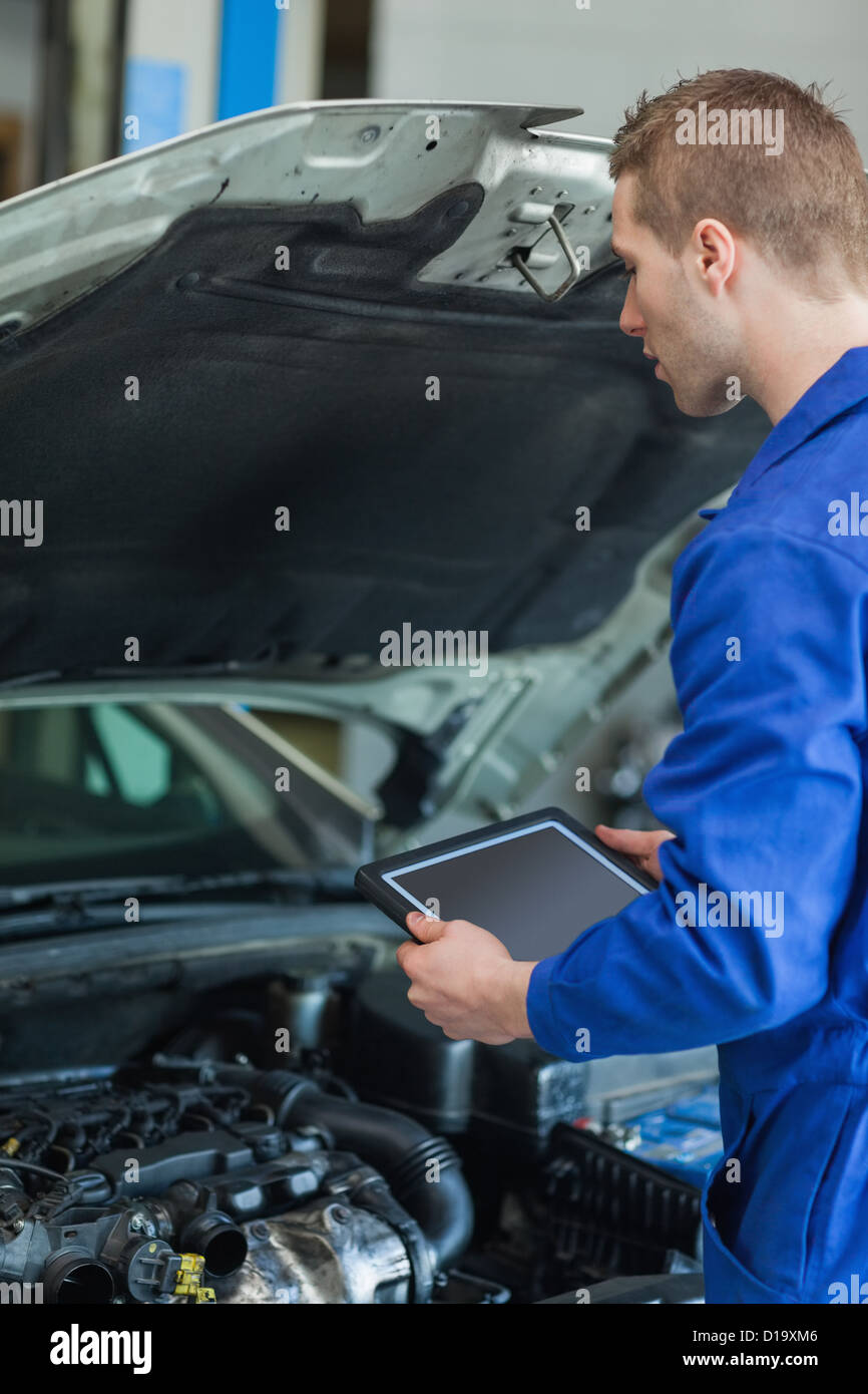 Mechaniker mit TabletPC Prüfung Automotor Stockfoto
