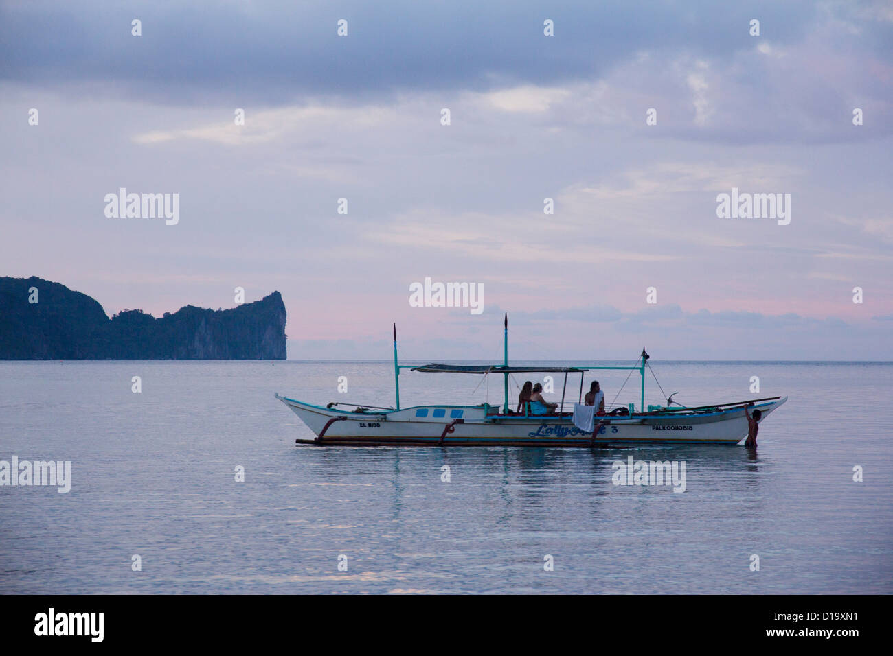 Ein Mann steuert ein Boot von einem Tag auf der Insel-hopping, El Nido, Palawan, Philippinen Stockfoto