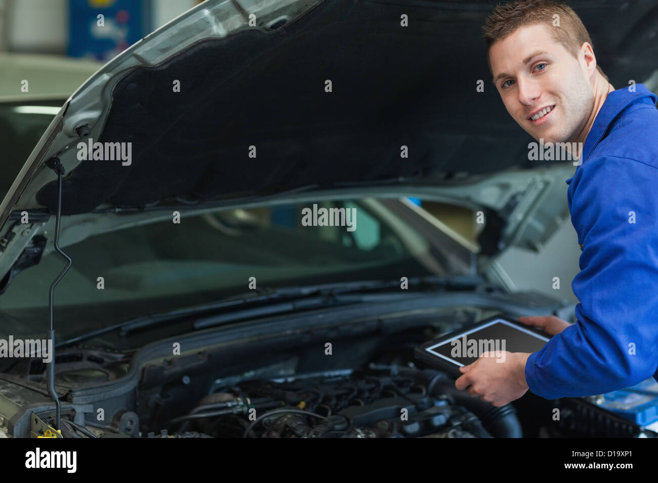 Mechaniker mit Tablet-Computer von Automotor Stockfoto