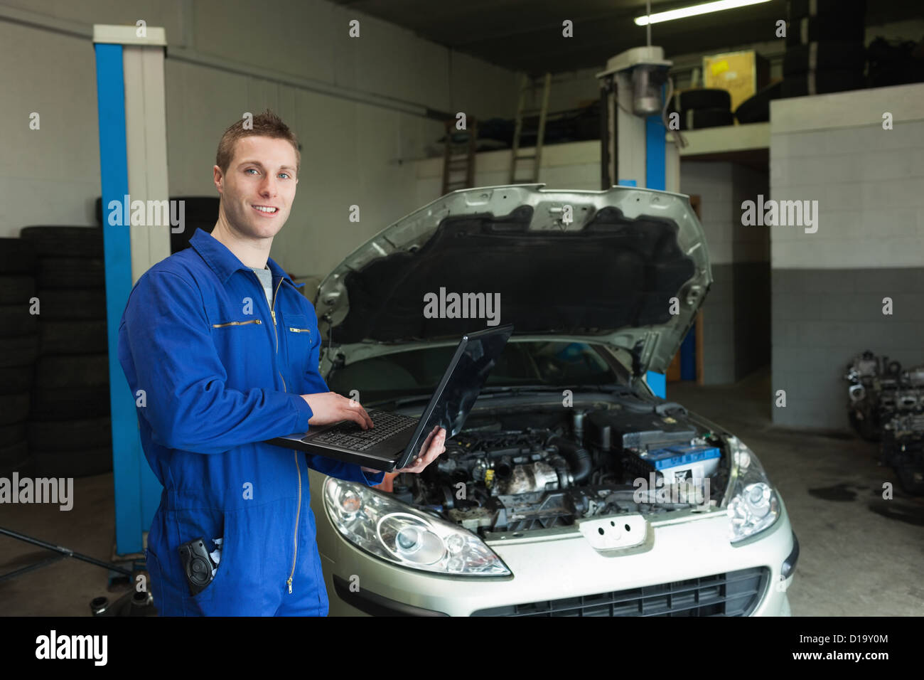 Mechaniker mit Laptop in Werkstatt Stockfoto