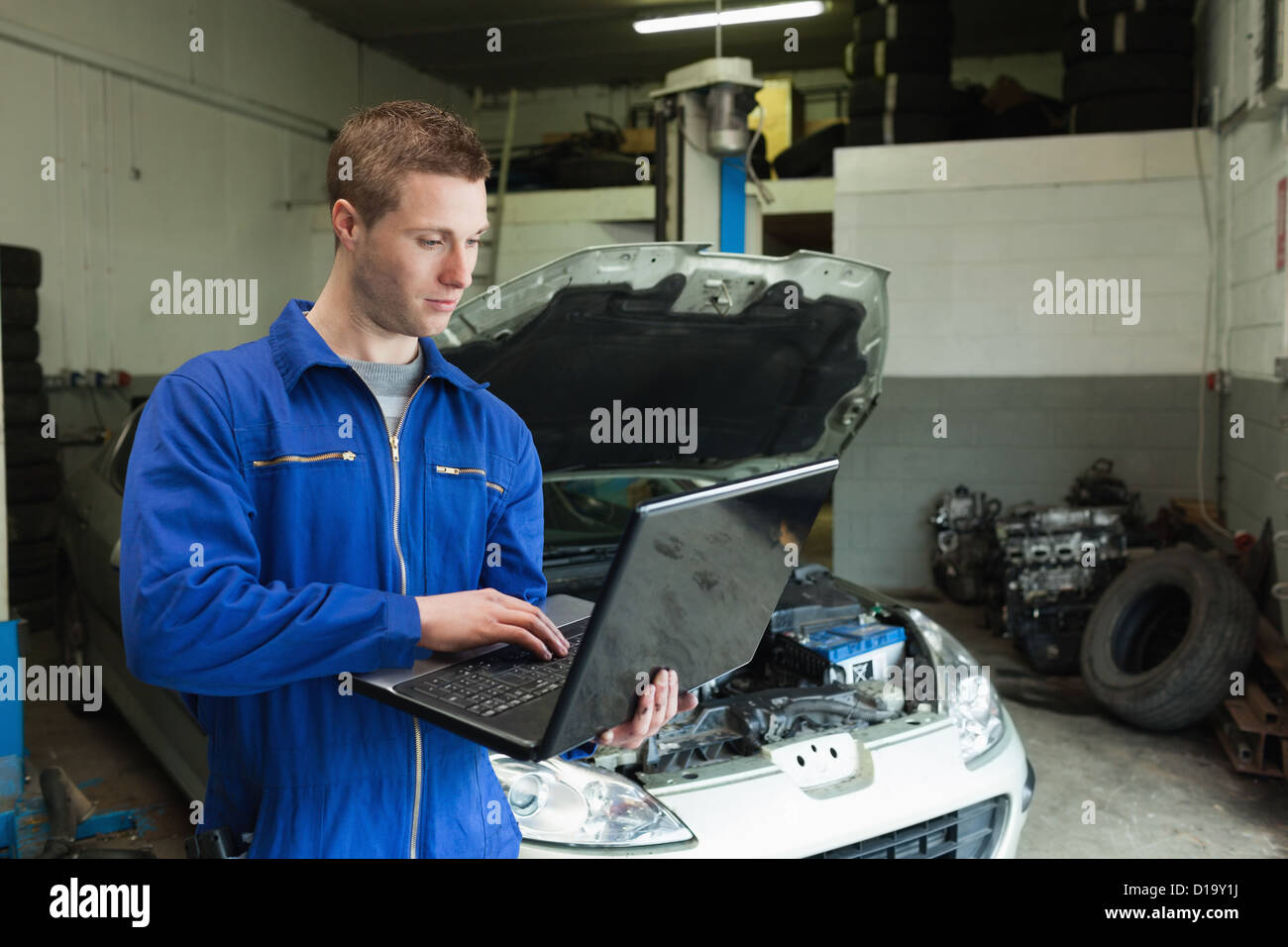 Mechaniker mit Laptop in garage Stockfoto