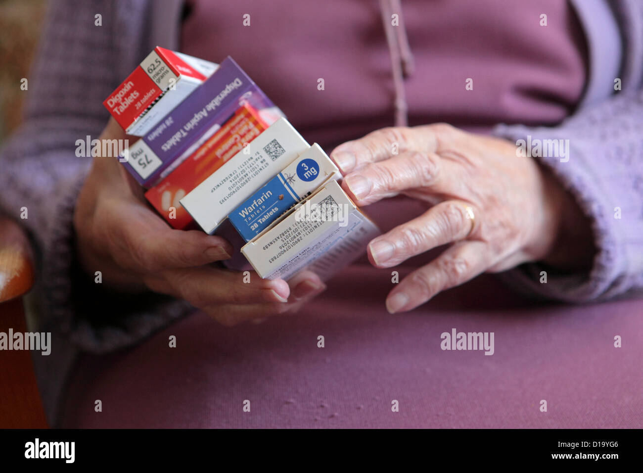 Ältere Frau an im Hause mit verwirrenden Reihe von verschiedenen täglichen Medikamente, Suffolk, UK Stockfoto