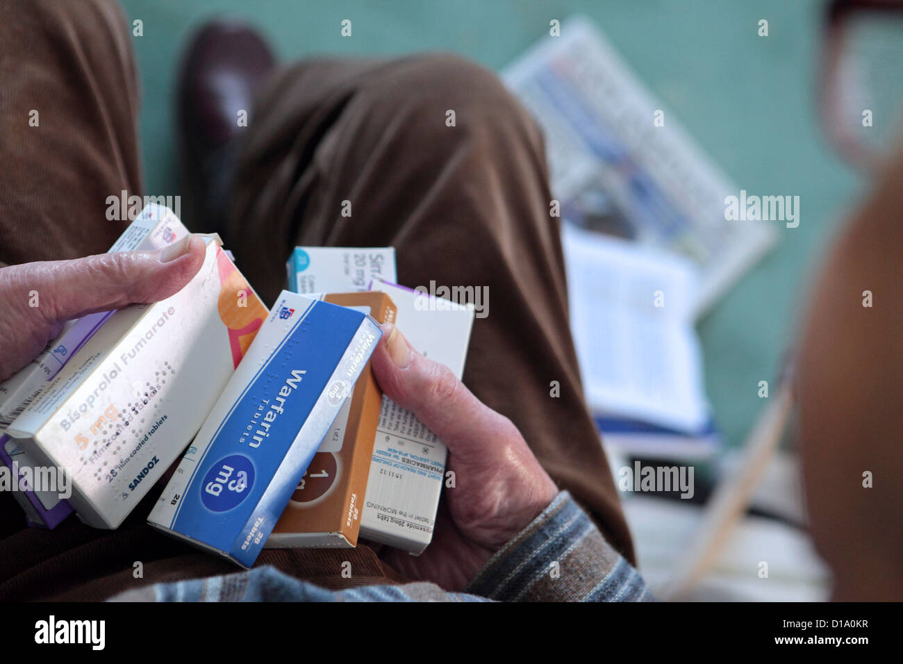 Älteren alten alternden Mannes Hände halten Medikamente Tabletten, Herz, Schmerzlinderung, bei im Hause, England UK Stockfoto