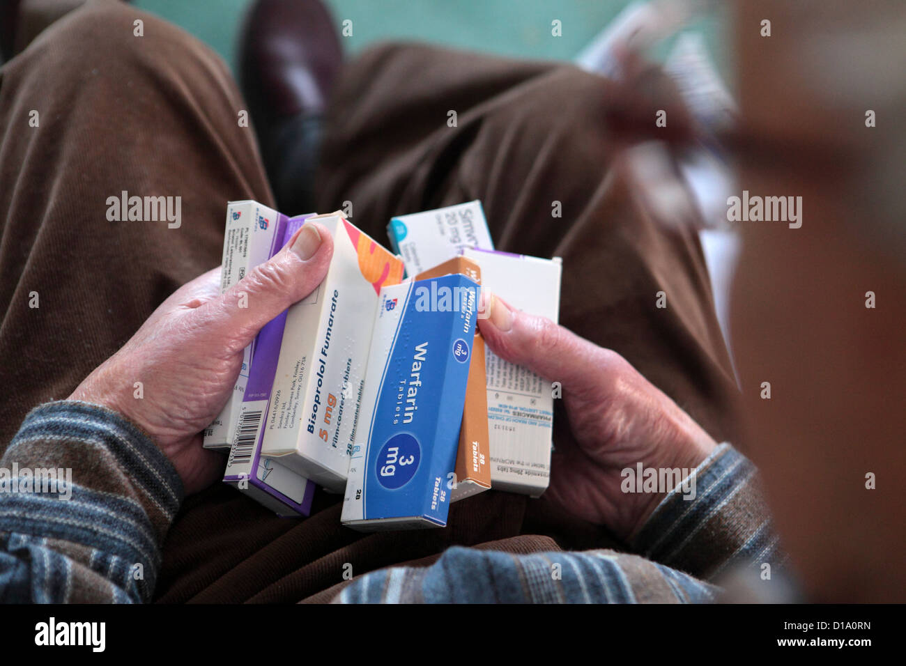 Älteren alten alternden Mannes Hände halten Medikamente Tabletten, Herz, Schmerzlinderung, bei im Hause, England UK Stockfoto