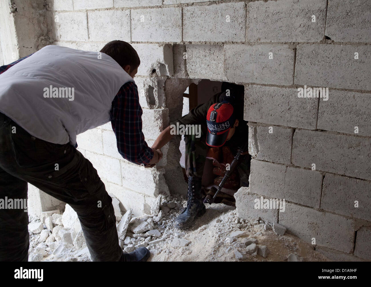 Aleppo, Syrien: Ein freie Syran Armee Kämpfer bekommt Hilfe durch Löcher in den Wänden in Amaria klettern. Viele Häuser hatten Löcher in Stockfoto