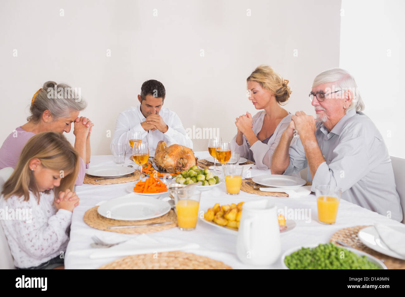 Familie sagen Gnade vor dem Essen eines Truthahn Stockfoto