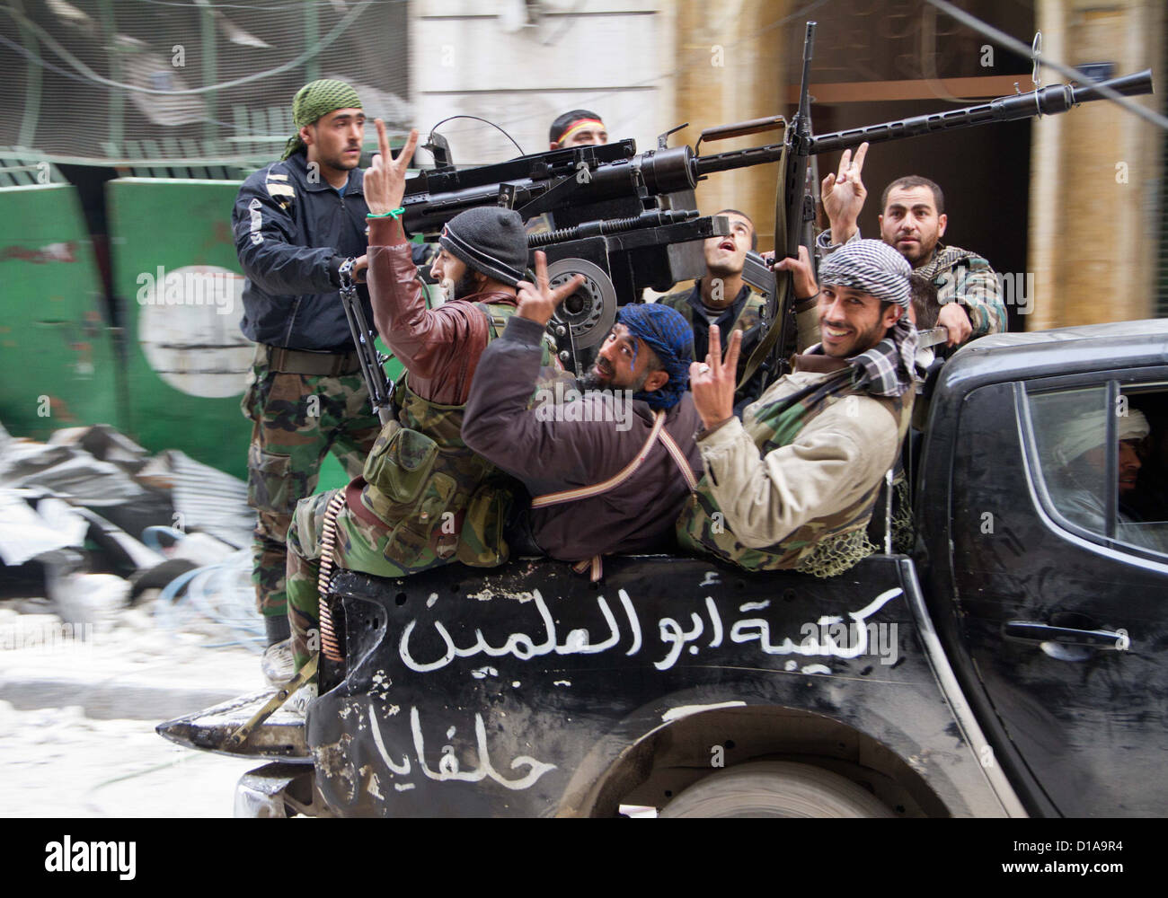 3. Dezember 2012 - Aleppo, Syrien: Freie Syrische Armee, die Kämpfer in den hinteren Teil eines Pickup-Trucks mit einem Dushka bewaffnet zu bekommen. Stockfoto