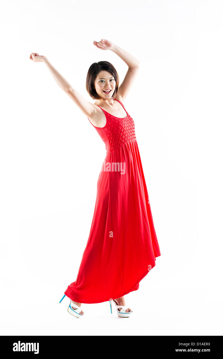 Glücklich Chinesin roten Sommerkleid tragen. Energetische voller Länge Portrait von eine junge schöne Frau. isoliert auf weißem backg Stockfoto
