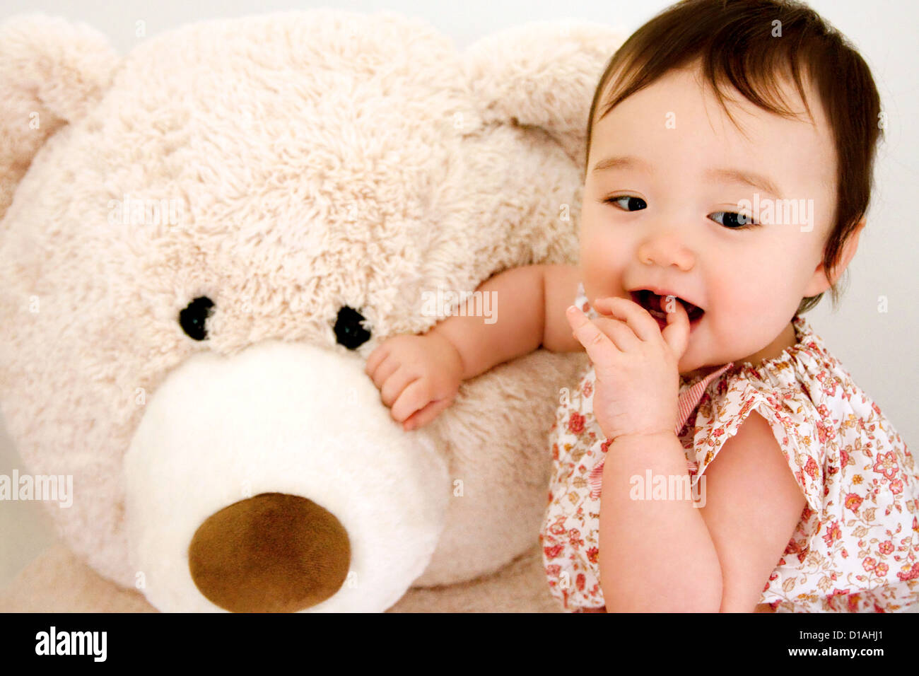 Süßes Babymädchen mit riesigen Teddybär Stockfoto