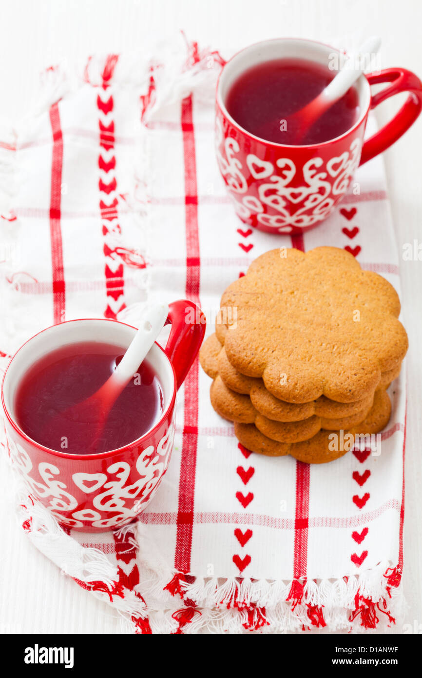 Weihnachten-Glühwein in zwei kleine rote Tassen und Lebkuchen vor weißem Hintergrund Stockfoto