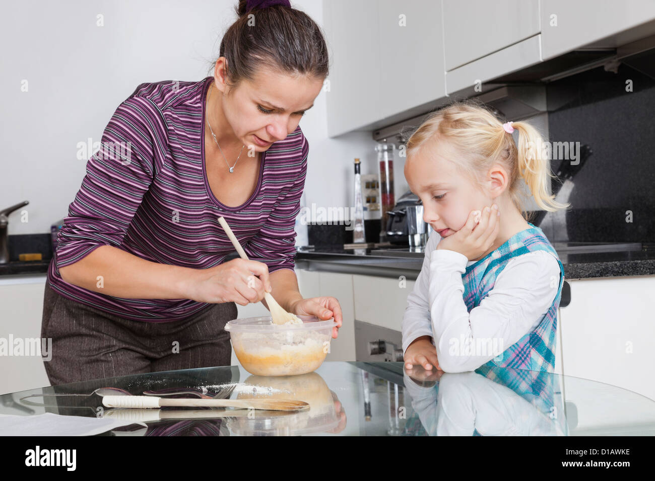 Mädchen auf der Suche bei Mutter in Küche Stockfoto