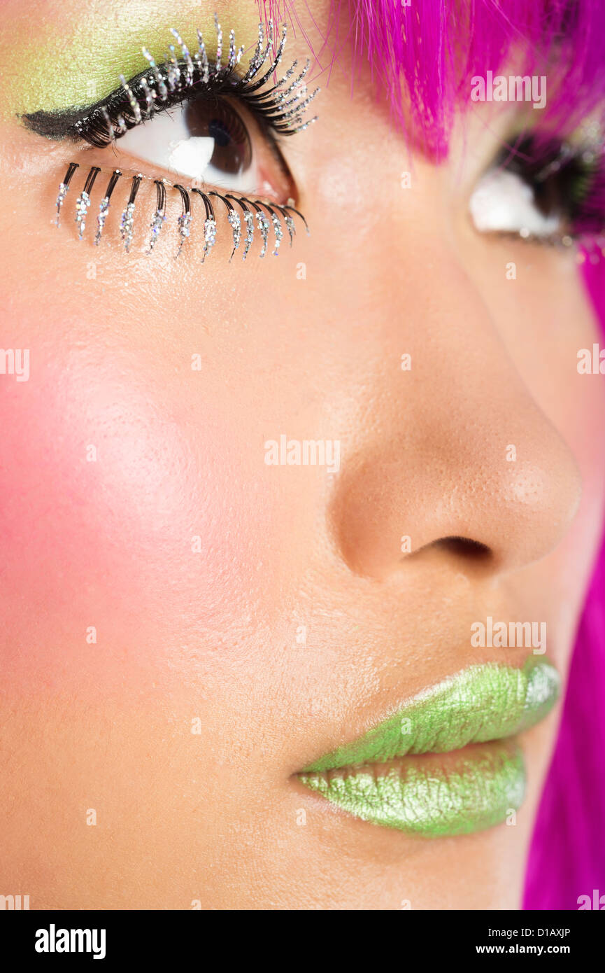 Extreme junge funky Frau Gesicht falsche Wimpern grünen Lippenstift Stockfoto