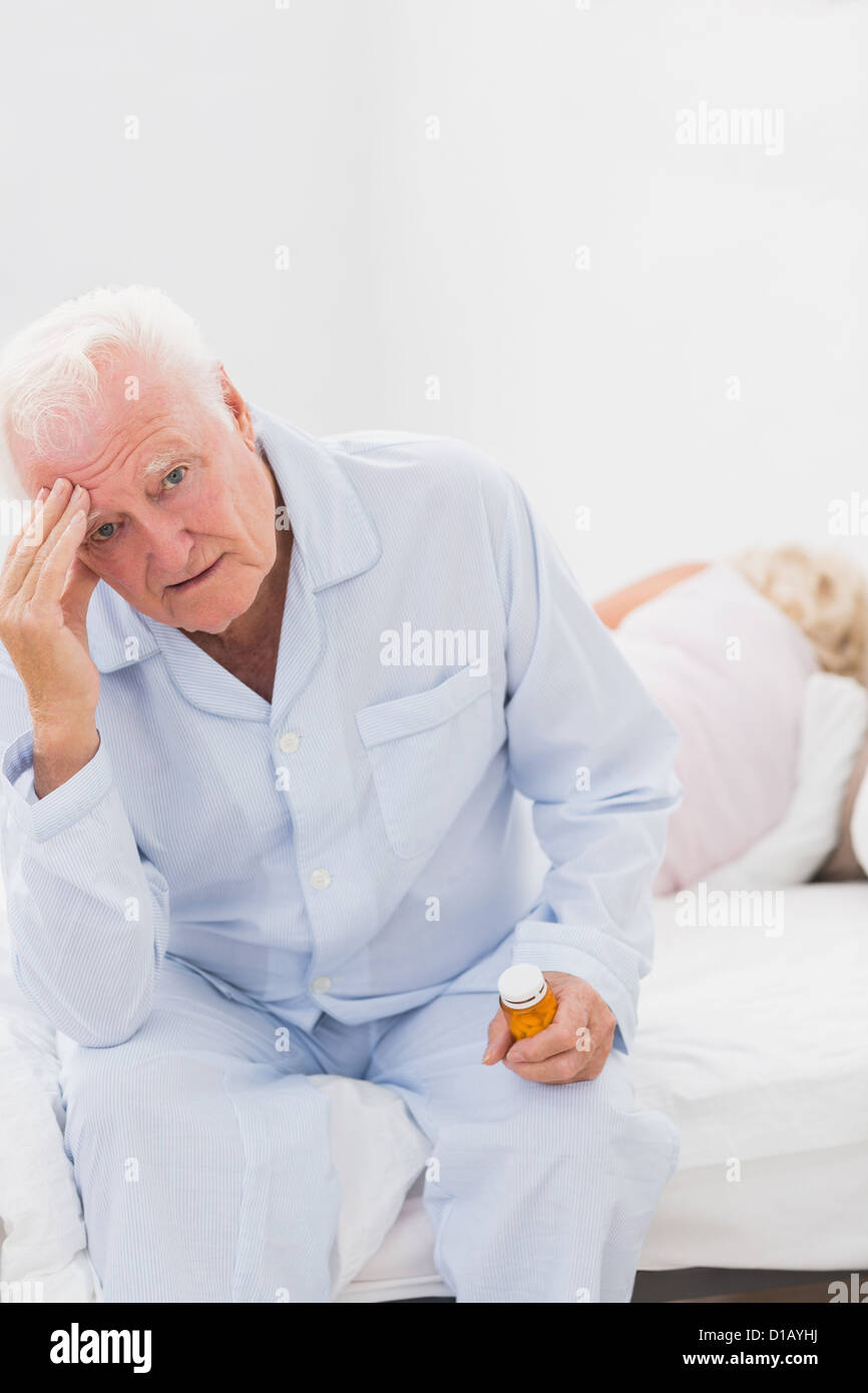 Ältere Menschen leiden, während die Frau auf dem Bett schlafen Stockfoto