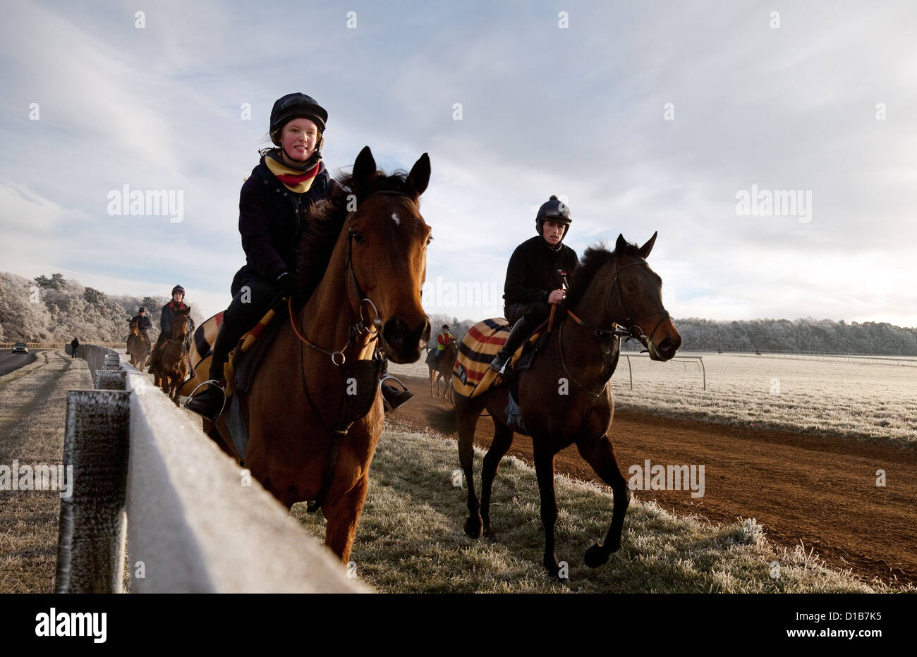 Pferde und Jockeys Reiten an einem Wintermorgen im Dezember, Newmarket Suffolk England UK Stockfoto