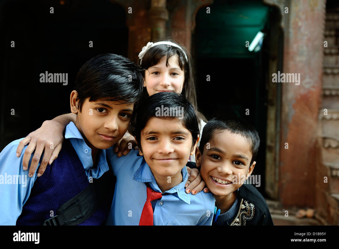 Dunkel-enthäutete indische Kinder und eine blasse europäischen durchstreifen in den Straßen der alten Bikaner; Rajasthan, Indien. Stockfoto