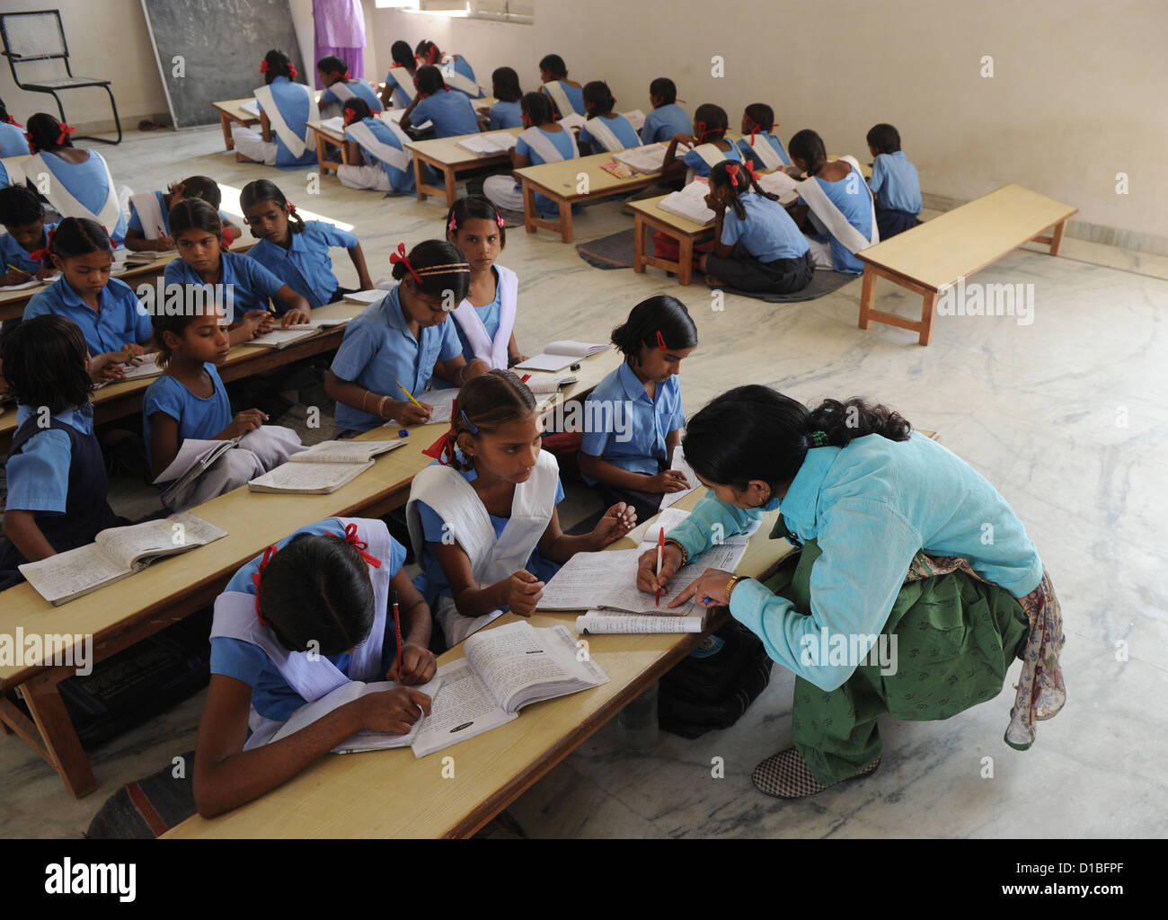 Ein Lehrer prüft den Lernfortschritt ihrer SchülerInnen an der Mädchenschule in Mundia in der Nähe von Jaipur, Indien, 19. November 2012. Bahadur Singh Rajawat spendete die Räumlichkeiten für die Schule mit seinem Bruder. Es wird auch unterstützt durch die deutsche Development Association "Mädchenschule Mundia" (Girls' School Mundia), Sitz in Monheim, Deutschland. Foto: Jens Kalaene Stockfoto