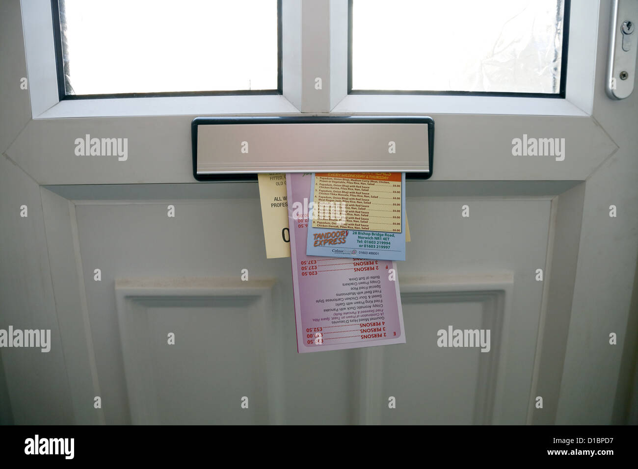 Junk-e-Mail durch ein Türen-Briefkasten geschoben. Stockfoto